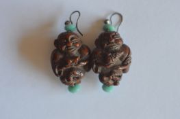 A pair of Chinese carved ear pendants mounted with loop tops. Est. £30 - £40.