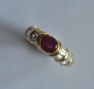 A good quality 18ct oval ruby and emerald cut cluster ring in rub over mount. Approx. 5 grams. The