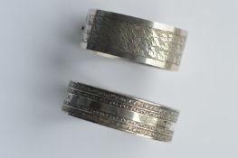 A silver hinged bracelet with engraving together w