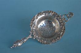 A heavy Continental pierced tea strainer with embo