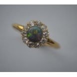 A good black opal and diamond cluster ring in 18 carat mount. Est. £600 - £800.