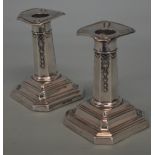 A pair of dwarf candlesticks on pedestal base and