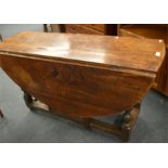 An Antique Oak drop leaf table on turned supports.