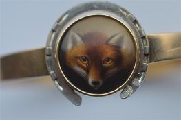 A good quality high carat bangle inset with oval porcelain miniature of a fox. surrounded by white