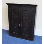 An Oak carved wall cabinet with fitted interior an