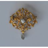 A heavy French scroll decorated brooch with lion mask decoration and large central diamond measuring