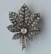 An attractive gold and silver brooch in the form of an open flower with large central stone. Est. £