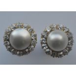 An attractive pair of pearl and gold ear studs with diamond surround in 18 carat gold. Est. £