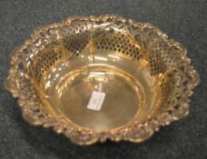 A circular sterling fruit dish heavily decorated with leaves and scrolls. Approx. 490 grams. Est. £