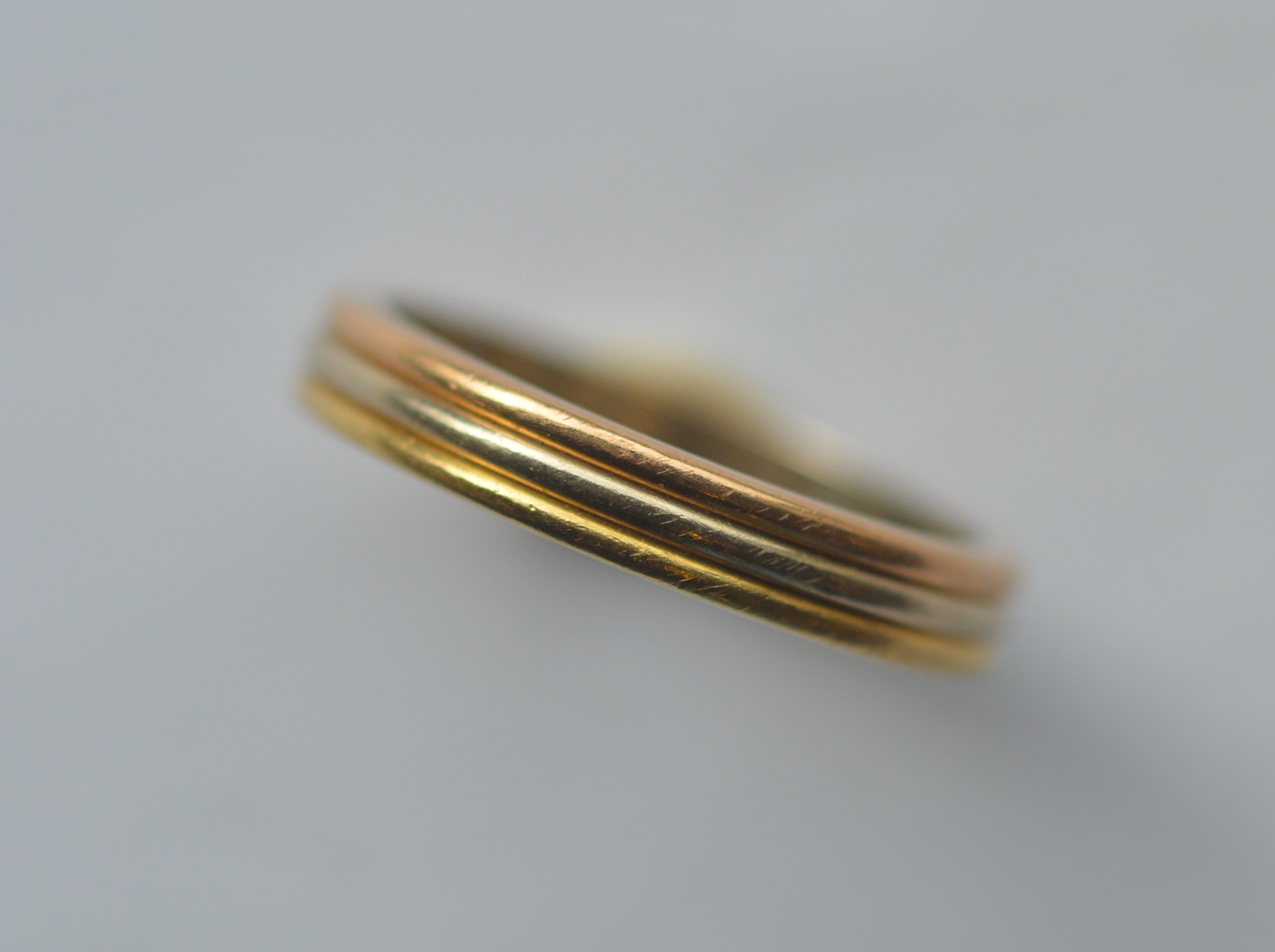 CARTIER: A good heavy wedding band of three colour gold. Numbered B33642. Finger size T. Approx. 6