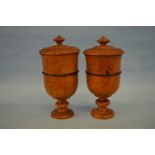 A good pair of urns with reeded decoration and lift off cover and pedestal base. Approx. 26cm