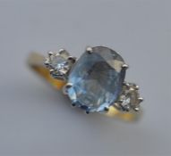 An 18 carat diamond and blue stone ring in claw mount. Est. £80 - £100.