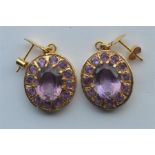 A pair of amethyst and gold drop earrings with loop tops. Approx. 12.7 grams. Est. £90 - £100.