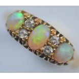 An opal and diamond seven stone half hoop ring in 18 carat band. Est £280 - £320.