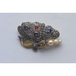 An unusual brooch in the form of a butterfly with sapphire and ruby body; the wings pavé set with