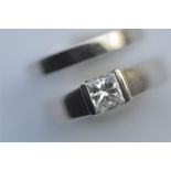 A heavy princess cut single stone ring in white gold mount together with matching wedding band. Est.