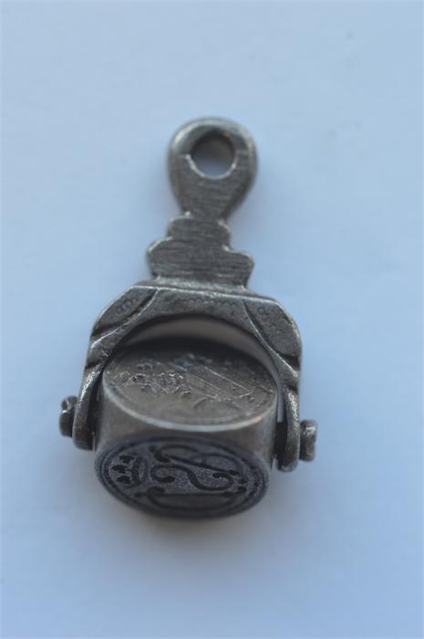 A steel triple spinning fob with crested decoration. Est £80 - £120.