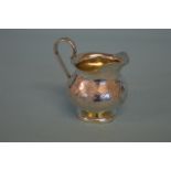 A Russian silver cream jug, the bulbous body on pe