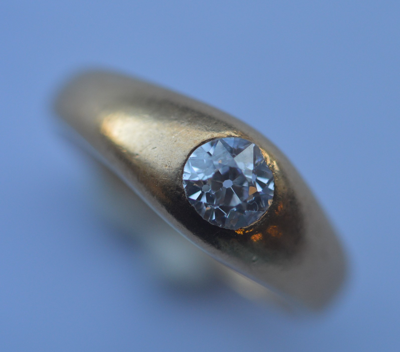 A small diamond single stone gypsy set ring in 18 carat rub over mount. Est. £150 - £200.