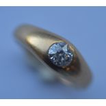 A small diamond single stone gypsy set ring in 18 carat rub over mount. Est. £150 - £200.