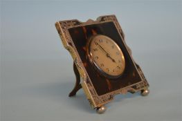 An attractive tortoiseshell dressing table clock with pierced border. London 1926. Est. £150 - £