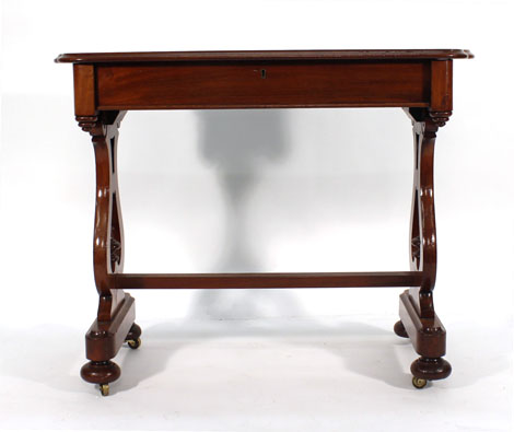 A Victorian mahogany library table with moulded serpentine top and frieze drawer on lyre-shaped