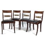 A set of six Regency mahogany, brass inlaid and parcel gilt dining chairs with upholstered drop in