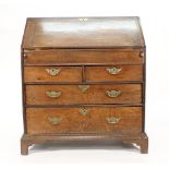 An early 18th century oak bureau, the fall front revealing a stepped fitted interior with well