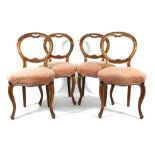 A set of four Victorian walnut framed dining chairs with moulded balloon backs on cabriole legs A