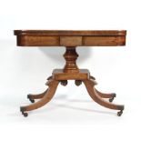 A Regency mahogany card table with fold over top on a turned support with quadruple sabre base, w.
