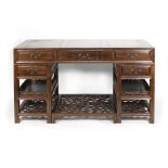 A Chinese elm writing desk with five drawers and open pedestals joined by a freestanding footrest,