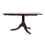 A Regency mahogany and crossbanded tilt top breakfast table on a tripartite base with brass claw-