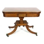 A Regency mahogany card table with fold over top on a turned support with quadruple sabre base, w.