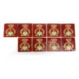 A group of nine Art Nouveau tiles, each decorated with a whiplash motif on a red ground, 15 x 15 cm