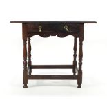 A George-II oak side table, the single frieze drawer over a shaped apron on four turned legs