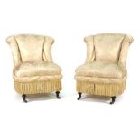 A pair of Edwardian fully upholstered parlour chairs on turned supports with castors CONDITION