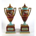 A pair of Vienna-style two handled urns and covers on square plinth bases, each decorated with a