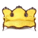 A 19th century mahogany and upholstered high back sofa, the Rococo-style frame incorporating fruit