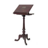 A mahogany adjustable music stand on a turned tapering column with three feet
*Bearing a plaque '