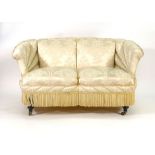 An Edwardian fully upholstered two seater boudoir sofa on turned feet with castors  CONDITION