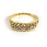 An 18ct yellow gold ring set five graduated diamonds in a raised openwork setting, ring size N