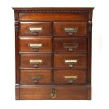 An early 20th century American walnut index cabinet of eight drawers on a plinth with a locking