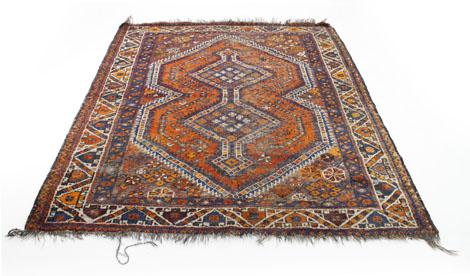 A Persian-style rug, the red ground decorated with a geometric design within a red and blue