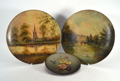 F. C. Gill, a pair of painted tole chargers depicting Warwick Castle and Stratford-on-Avon church,