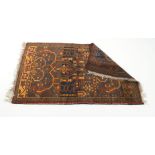 A Turkoman-style rug, the blue ground within a red border, 130 x 82 cm, together with another,