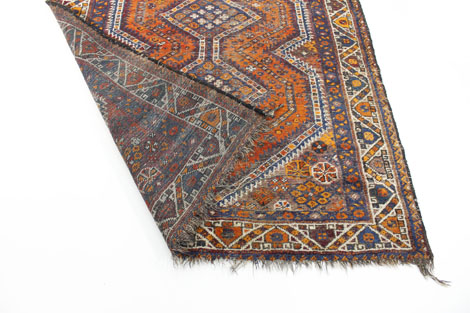 A Persian-style rug, the red ground decorated with a geometric design within a red and blue - Image 2 of 2