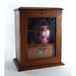 An Edwardian oak and glazed smokers cabinet, h. 28 cm, together with an associated tobacco jar