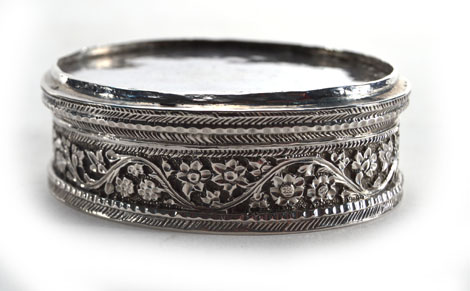 An Anglo Indian metalware lidded container of oval form with foliate border, unmarked, w. 6.5 cm - Image 2 of 2