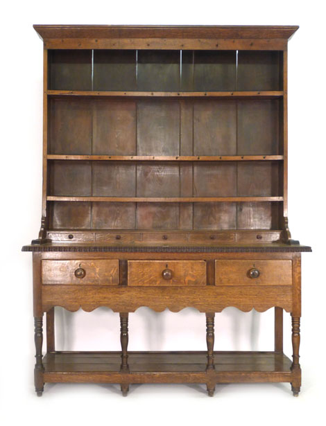 An 18th century-style oak dresser, the three tier plate rack above a superstructure with five faux