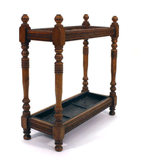 An oak umbrella stand, the top with two turned partitions over a fitted tray joined by turned